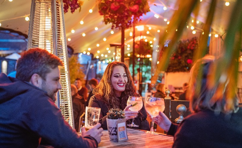 Three people having drinks on the covered terrace at Racks